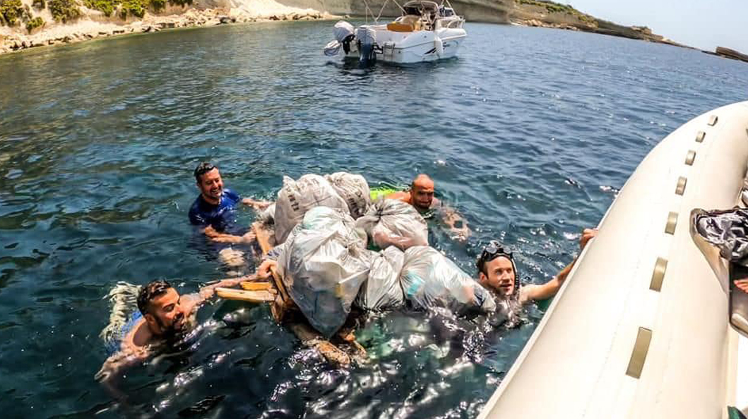 A group of employees collects waste from the sea 